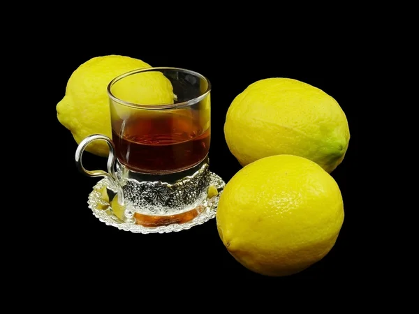 Cup met hete thee en drie citroenen — Stockfoto