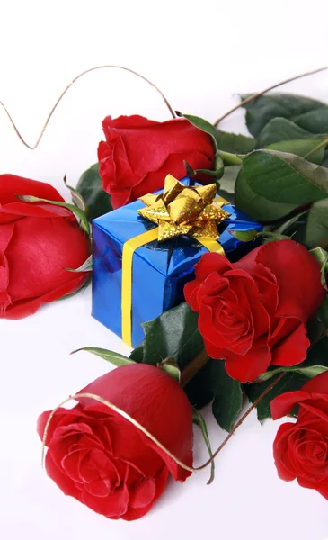 Červené růže a dárek — Stock fotografie
