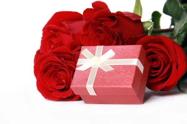 Красные розы и подарок — стоковое фото