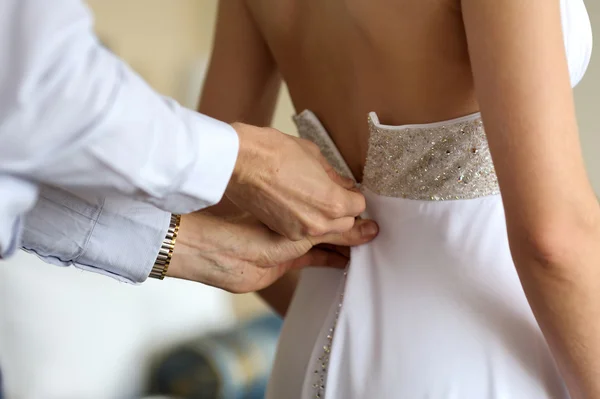 Bruidegom helpen birde trouwjurk zetten — Stockfoto