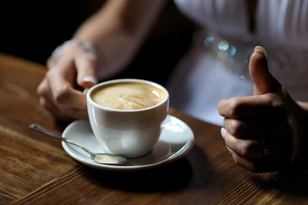 Bride's hands holding cup of coffe — Stock Photo, Image