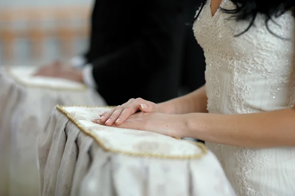Bruidskamer handen close-up tijdens kerk ceremonie — Stockfoto