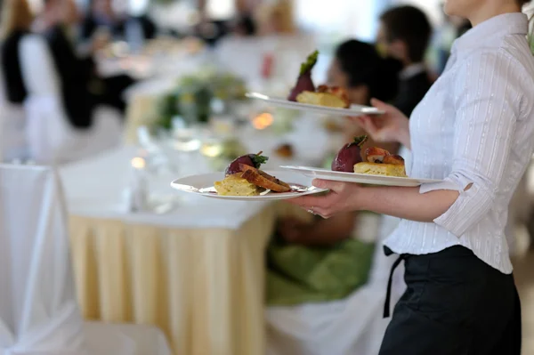 Официантка с тремя тарелками — стоковое фото
