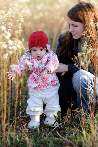 牧草地で赤ちゃんを持つ若い母親 — ストック写真