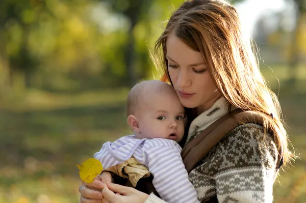 캐리어에 그녀의 아기와 함께 젊은 어머니 — 스톡 사진