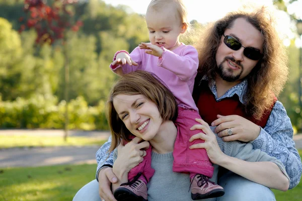 Young family in a park — Stock Photo, Image