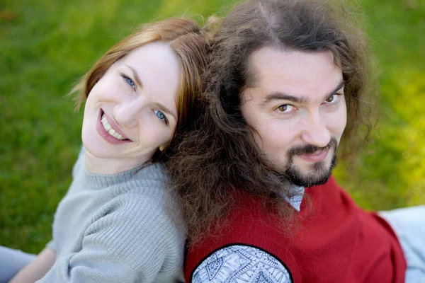 年轻夫妇坐在草地上 — 图库照片