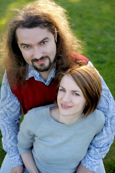 草の上に座っている若いカップル — ストック写真