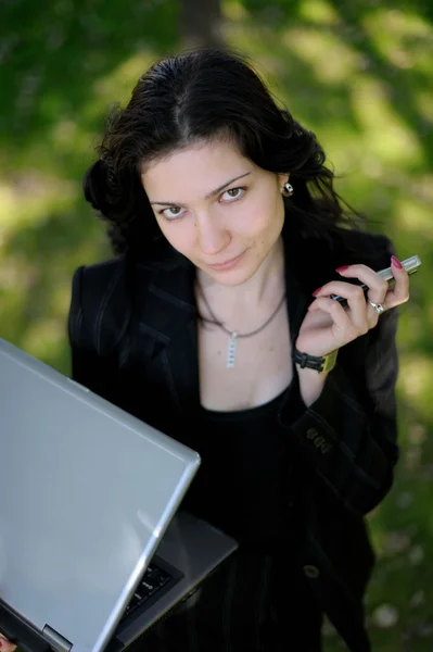 Young lady outside with laptop and cell — Stock Photo, Image