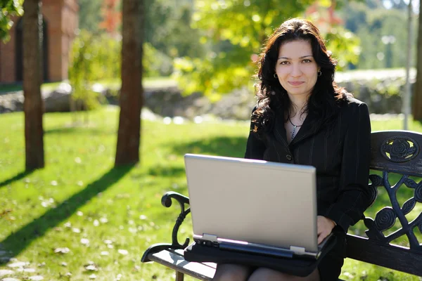 Young lady with a notebook in a park — Stock Photo, Image