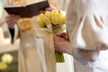 Bride's close-up with tulips during ceremony clipart