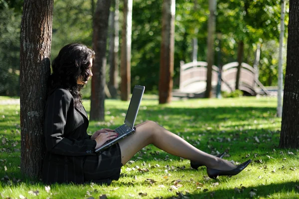 एक पार्क में एक नोटबुक के साथ एक युवा महिला — स्टॉक फ़ोटो, इमेज