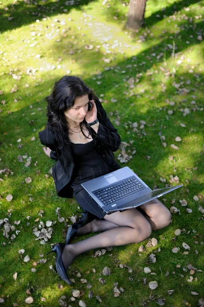 Giovane signora con un quaderno in un parco — Foto Stock