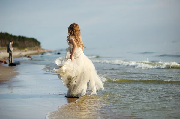 Panna młoda spacerująca wzdłuż wybrzeża morskiego — Zdjęcie stockowe