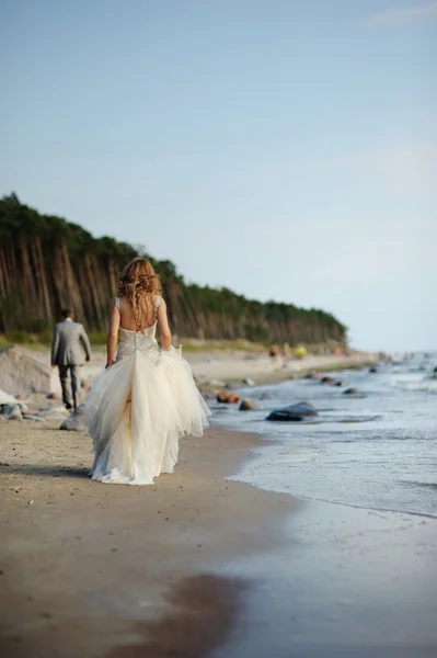 Gelin deniz kıyısında yürüyor — Stok fotoğraf