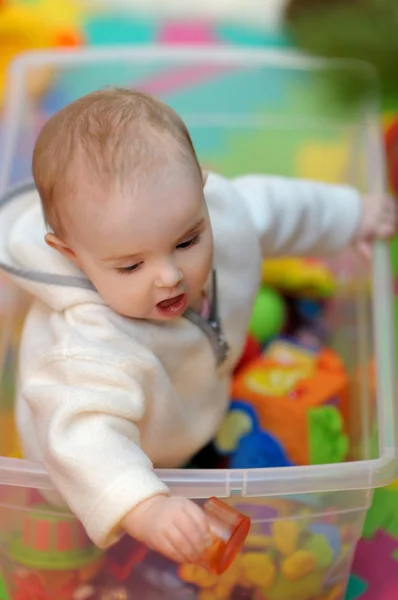 Söt liten tjej i en leksak låda — Stockfoto