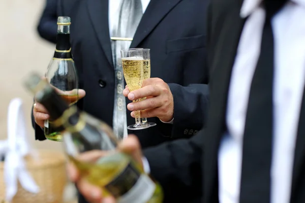 Groom segurando garrafa e copos de champanhe — Fotografia de Stock