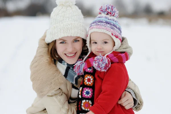 Kış bebeği kız ve genç annesi — Stok fotoğraf