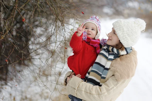 Маленькая зимняя девочка и ее молодая мать — стоковое фото