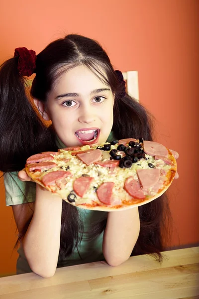 Молодая девушка ест большую пиццу — стоковое фото