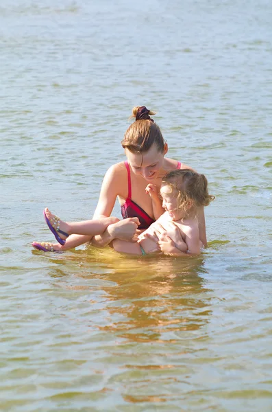 Liten flicka med mamma i floden — Stockfoto