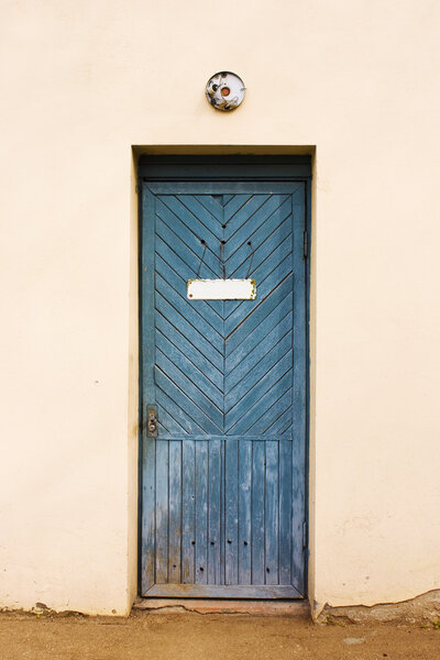 Blue vintage door with empty white doorplate