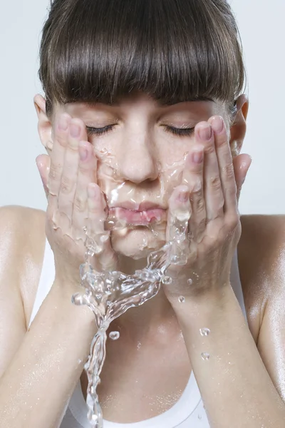 美しい女性が彼女の顔を洗う — ストック写真
