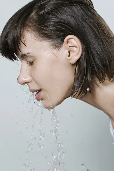 Vrouw die haar gezicht wast Stockafbeelding
