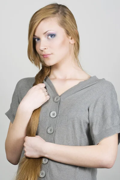 Chica joven sosteniendo pelo largo rubio — Foto de Stock