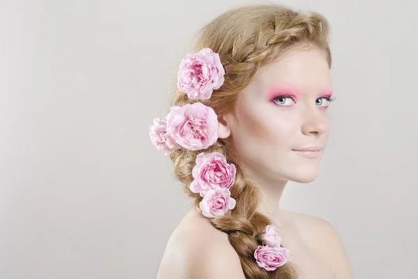Женщина с розовыми цветами в волосах — стоковое фото