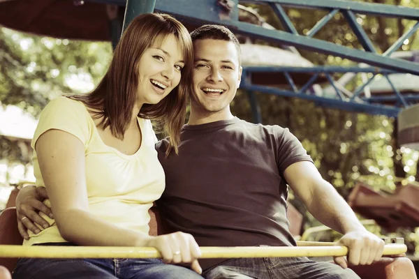 Směje se pár na karuselu — Stock fotografie