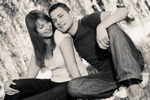 Портрет веселой пары, сидящей под деревом — стоковое фото