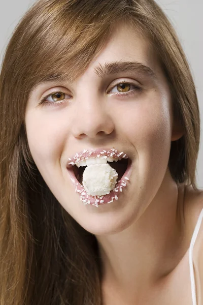 Женщина, кусающая белые конфеты — стоковое фото