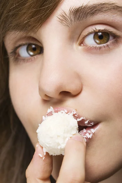 Женщина, кусающая белые конфеты — стоковое фото