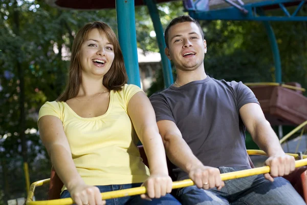 Laughing couple on the carousel — Stock Photo, Image