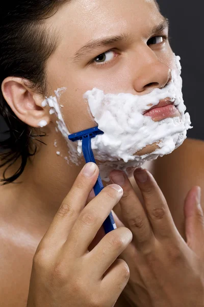 Красивый мужчина бреется — стоковое фото