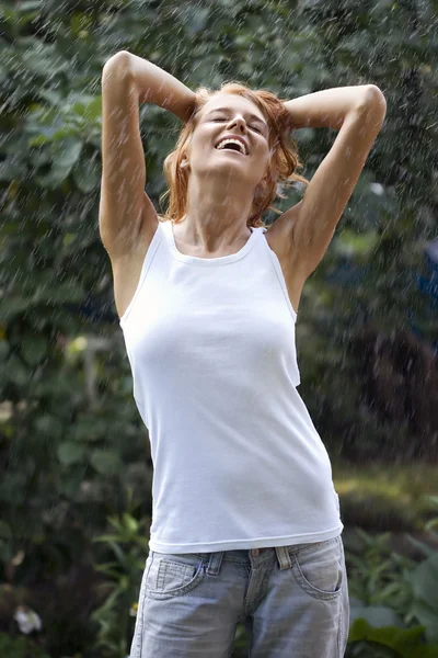 Ung kvinna njuter av regn — Stockfoto