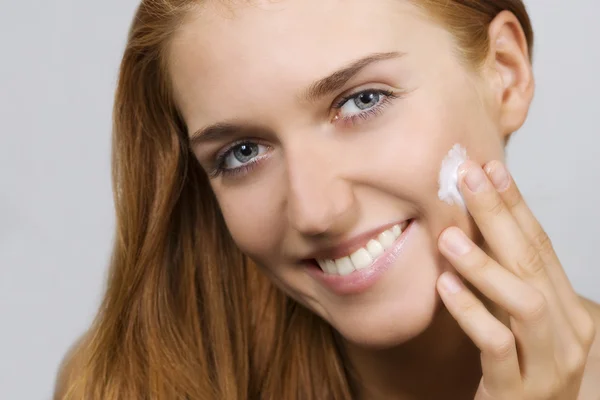 Hermosa mujer aplicando crema en su cara —  Fotos de Stock