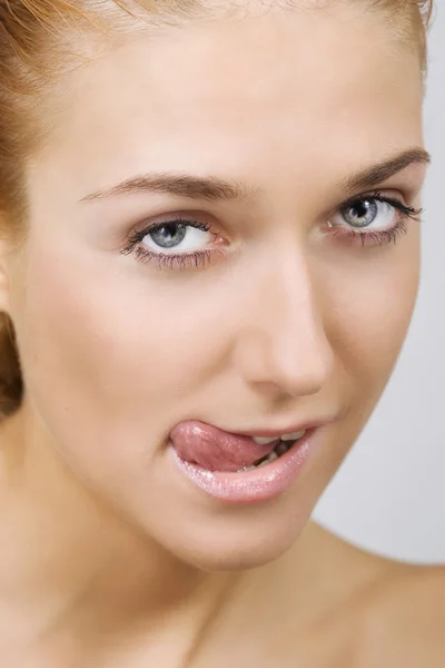 Frau streckt die Zunge heraus — Stockfoto