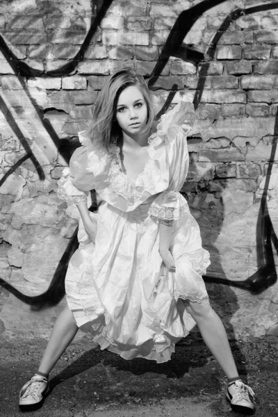 Модна модель в сукні на стіні з графіті — стокове фото