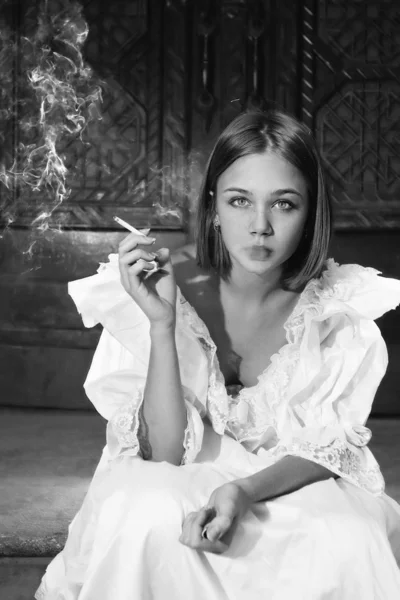 Beautiful woman in dress smoking — Stock Photo, Image