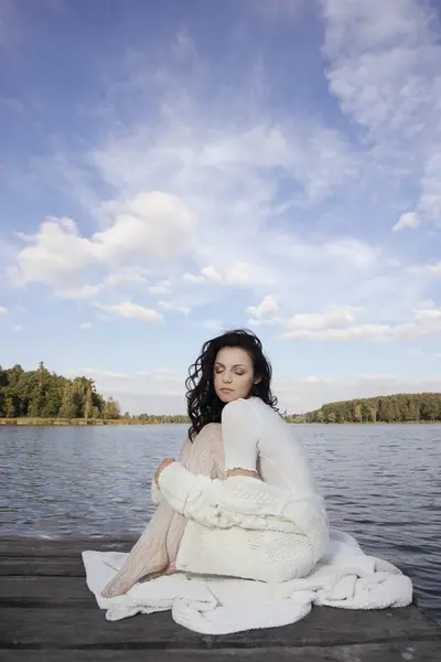 Schöne Frau sitzt auf der Seebrücke — Stockfoto