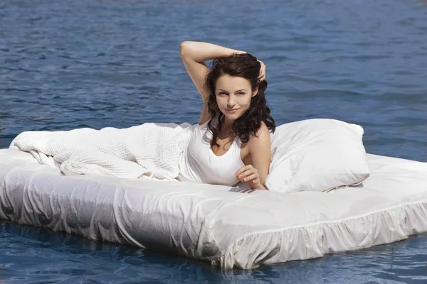 Woman lying on the bed in the sea — Stock Photo, Image