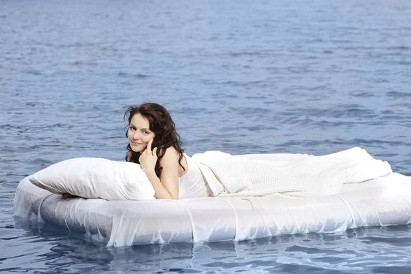 stock image Woman lying on the bed in the sea