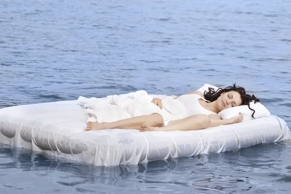 Mulher dormindo na cama no mar Fotografia De Stock