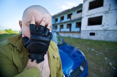 Portrait of a skinhead man near ruined building. clipart