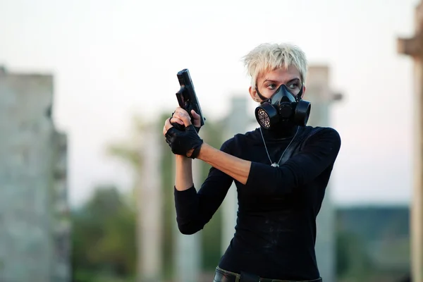 Ξανθιά γυναίκα στη μάσκα αερίου με το πιστόλι — Φωτογραφία Αρχείου