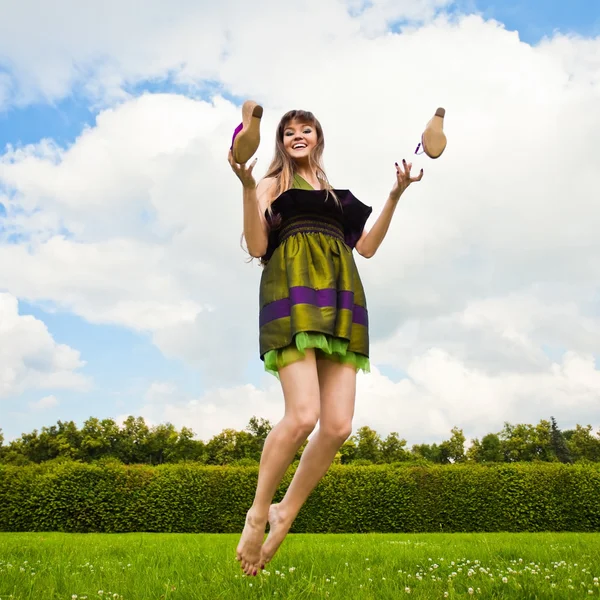 stock image Smiling girl is jumping on green meadow