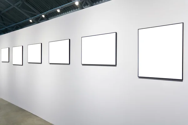 Witte muur in museum met frames — Stockfoto