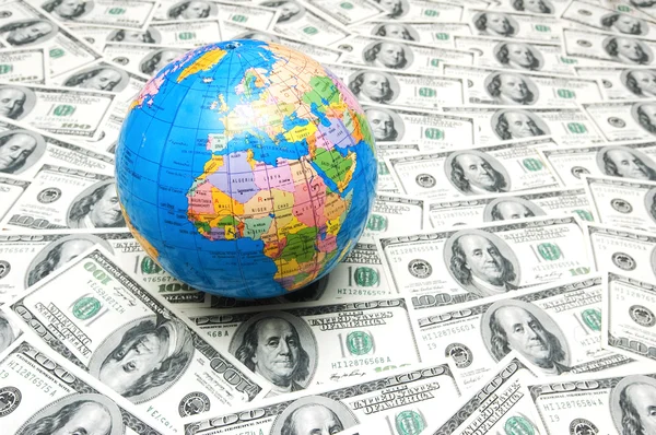 stock image Globe over many dollars